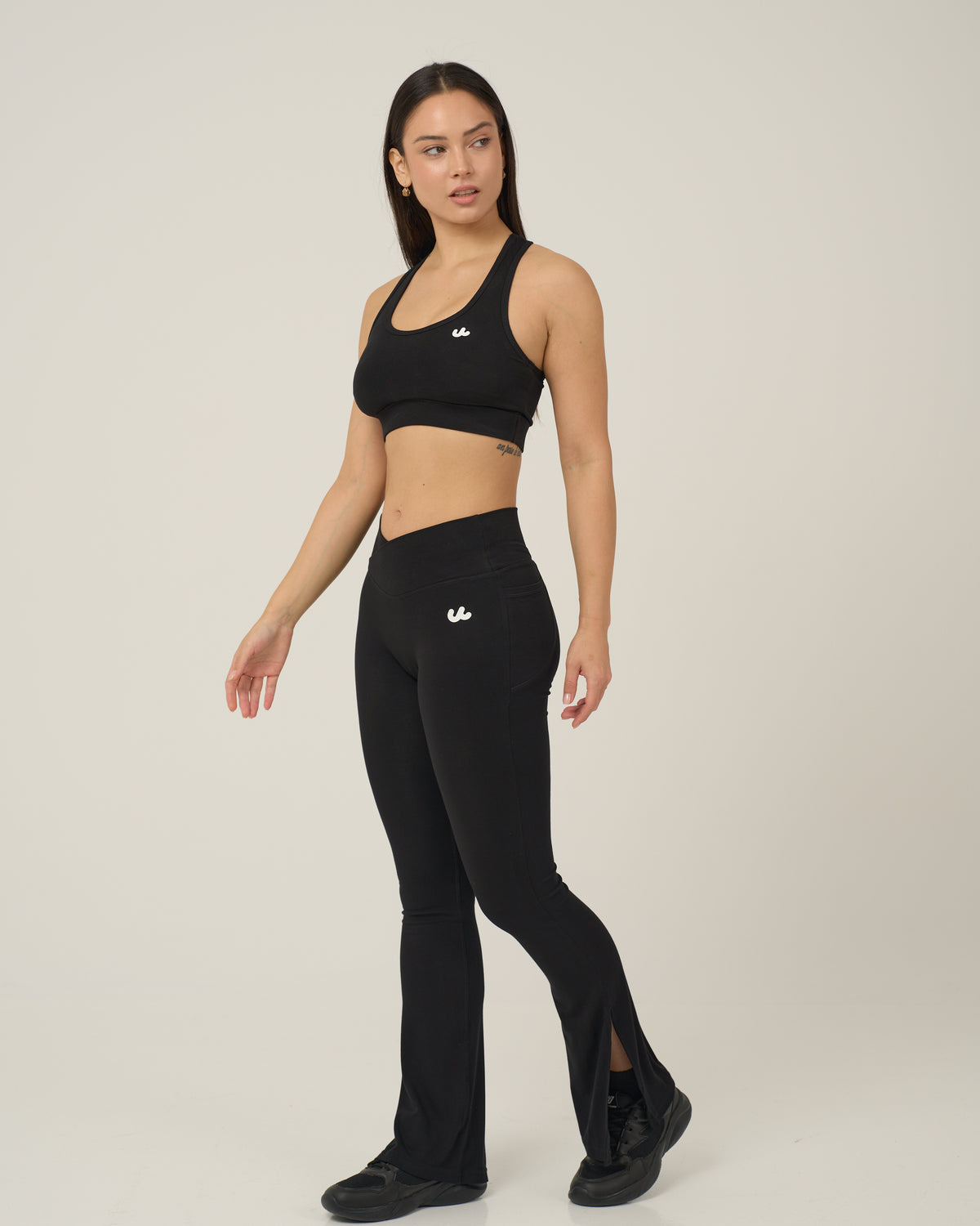 Urthlete bamboo sports bra in coal black with flare leggings, full length view
