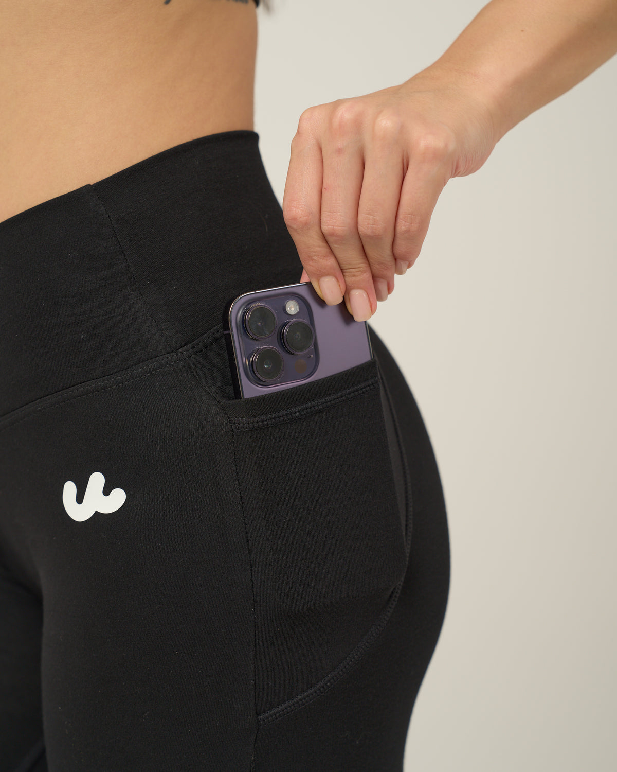 Side pocket of the Urthlete flare leggings holding a phone