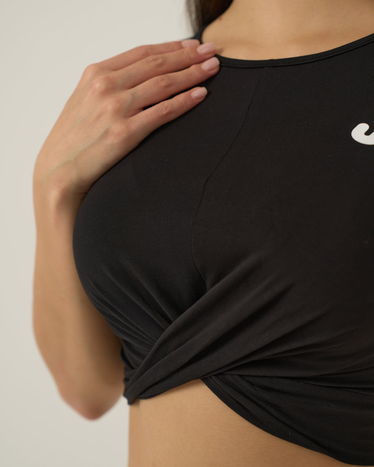 Detail of the Urthlete fitted tank fabric and logo in coal black